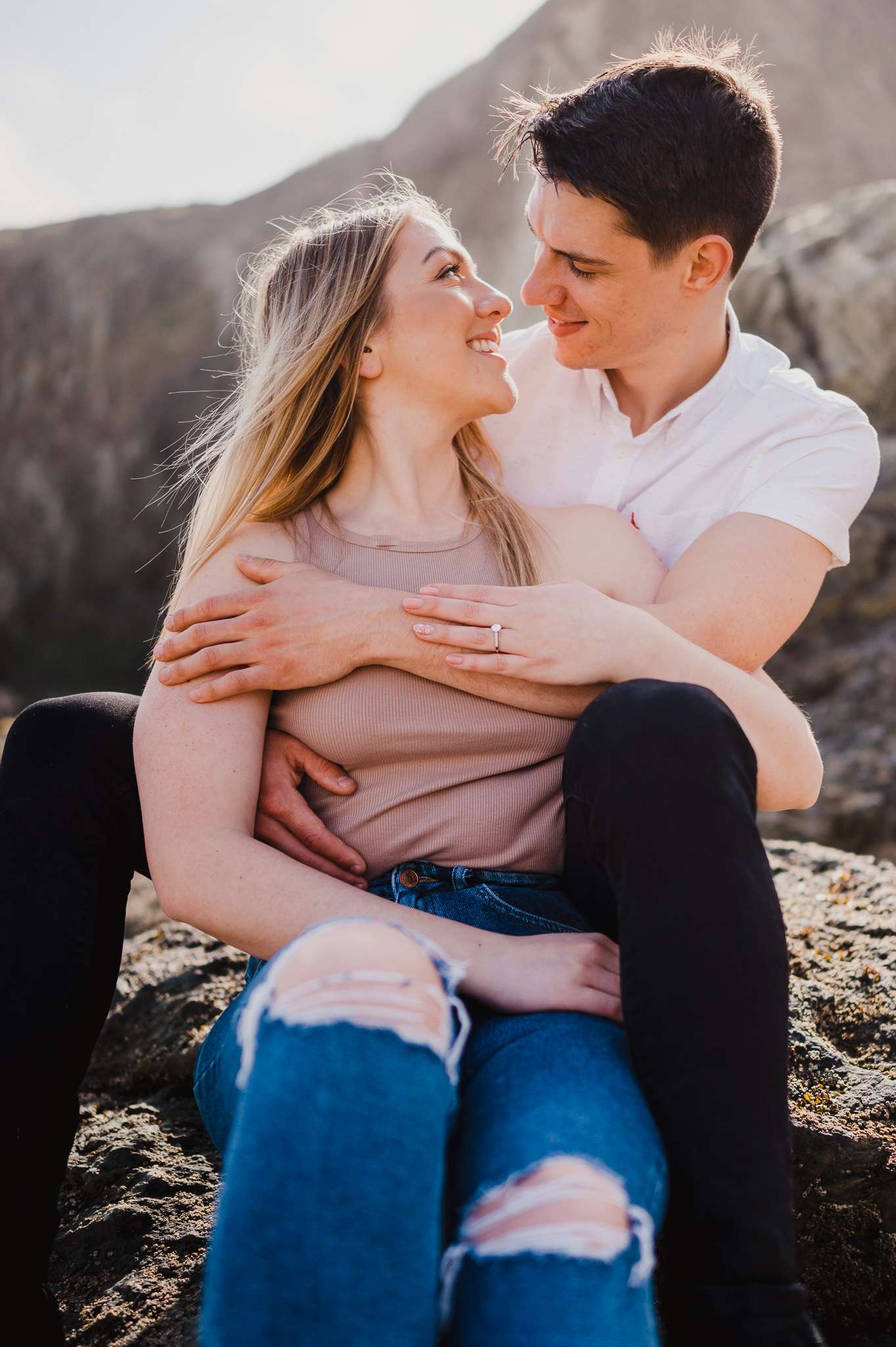 Photo of the happy couple sitting at Holywell bay during an engagement shoot celebrating their Proposal at Holywell Bay, Cornwall, UK