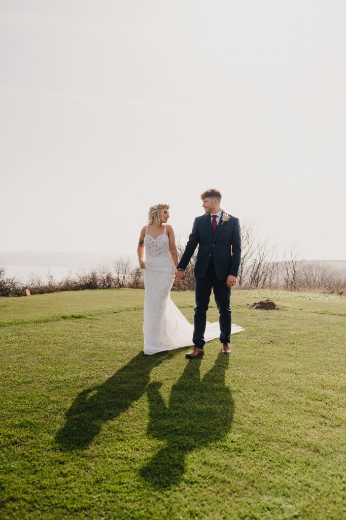Bride and groom on the gold course overlooking Falmouth at Above The Bay - Top 5 Coastal Venues in Cornwall