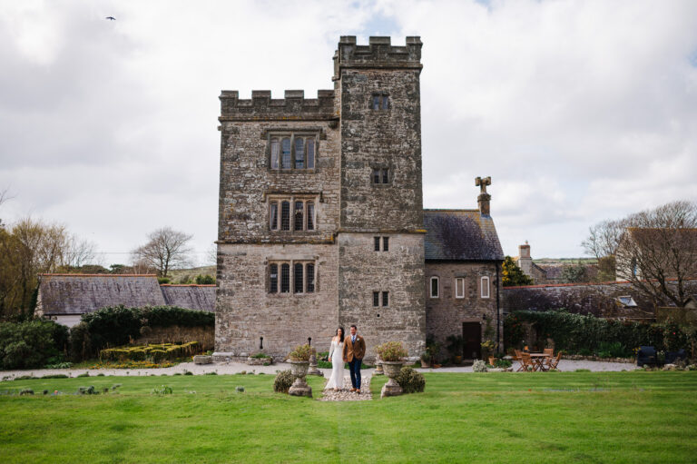 Couple walking outside of Pengersick Castle - Boho Cornwall Elopements - Top 5 Coastal Wedding Venues in Cornwall