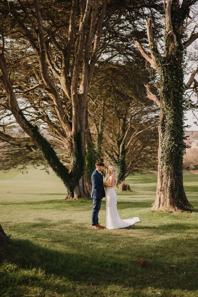 Best Places To Elope In Cornwall | Cornwall Wedding Photographer | Bride and Groom Walking Through Trees