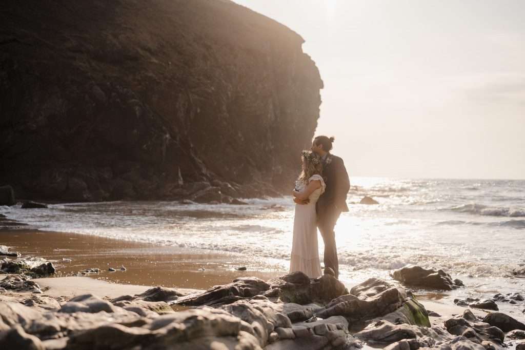 Wedding VS Elopement - The Difference - Eloping at Chapel Porth - Standing on beach as the sun sets