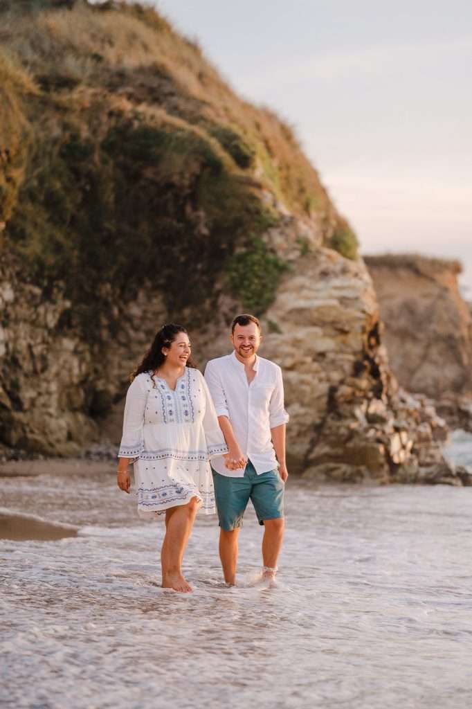 Happy couple celebrating their engagement at a beach in Cornwall