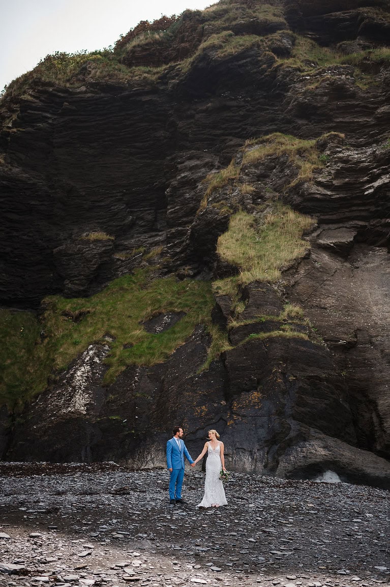 Celebrating their elopement by having a walk on a beach in Devon - Wedding Vs Elopement