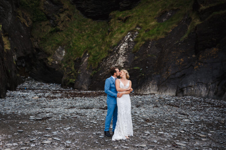 Wedding couple celebrate just getting married with a beach walk at the dramatic Tunnels wedding venue - Top Wow Factor Wedding Venue in Cornwall and Devon