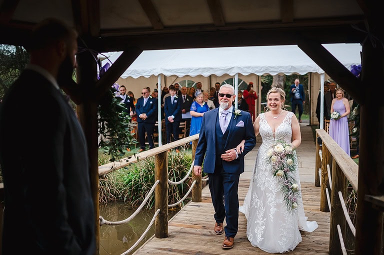 Bride walking down the aisle to the pagoda at Chycara wedding venue 