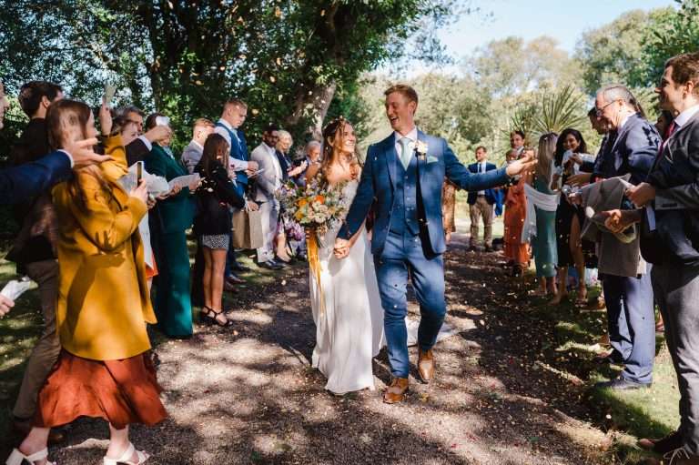 Wedding couple get covered in confetti outside at Chycara - How To Pick Your Perfect UK Wedding Venue - Your Ultimate Guide