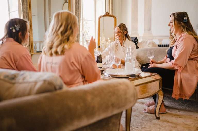 Bride and bridesmaids enjoying themselves at bridal prep - How To Pick Your Perfect UK Wedding Venue - Your Ultimate Guide