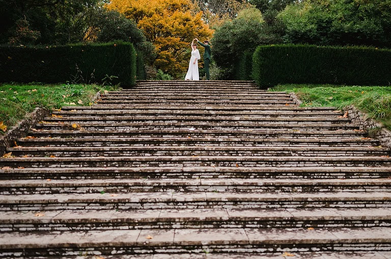 Wedding couple dance at top of the steps at Dartington Hall