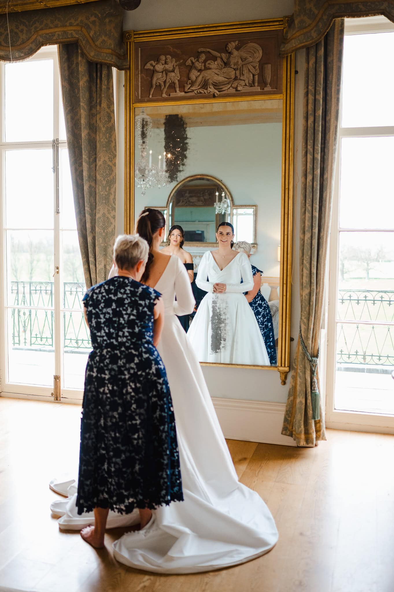 Mother of the bride doing up the back of the wedding dress