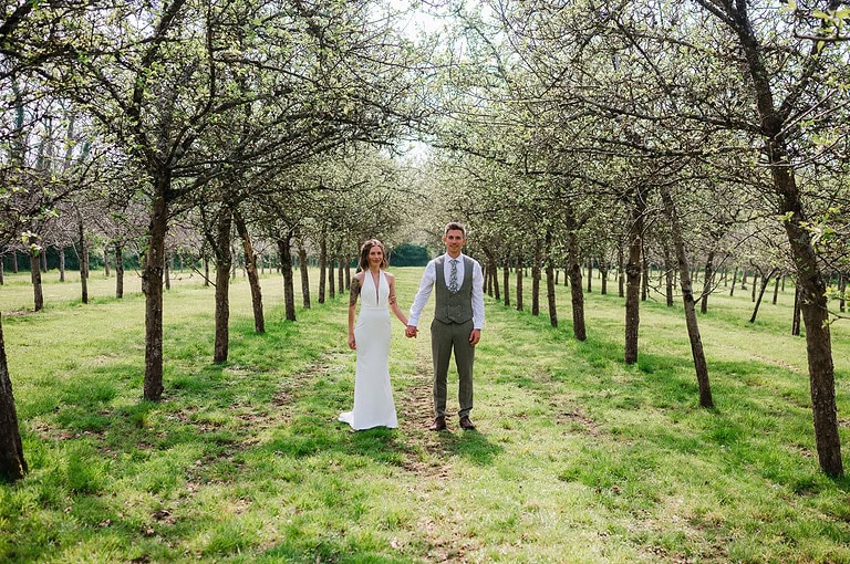 Just married and standing in the apple orchard at Froginwell Vineyard - Wedding Apps: The 5 Wedding Planning Apps My Couples Are Loving