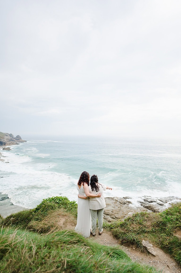 Wedding elopement couple looking out to sea from Cornwall - How To Plan A Destination Wedding