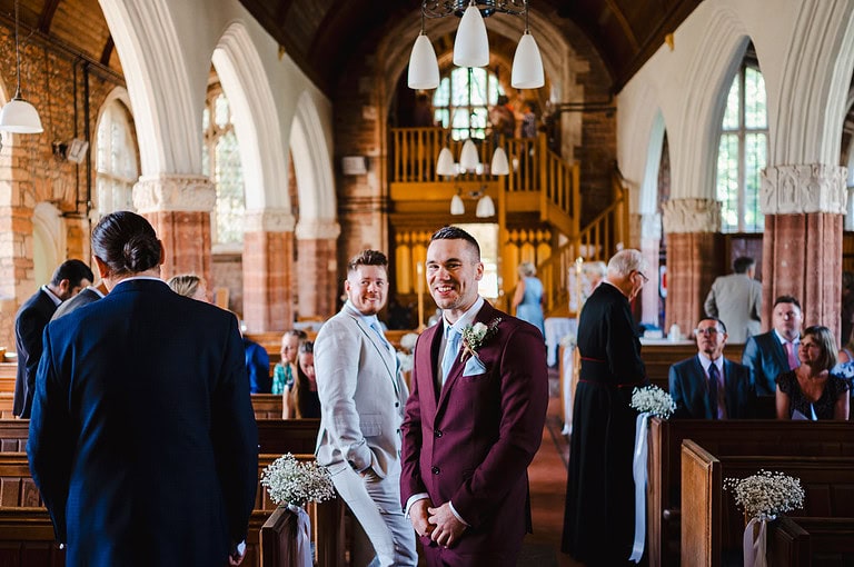 Groom waiting at the end of the aisle happy and excited