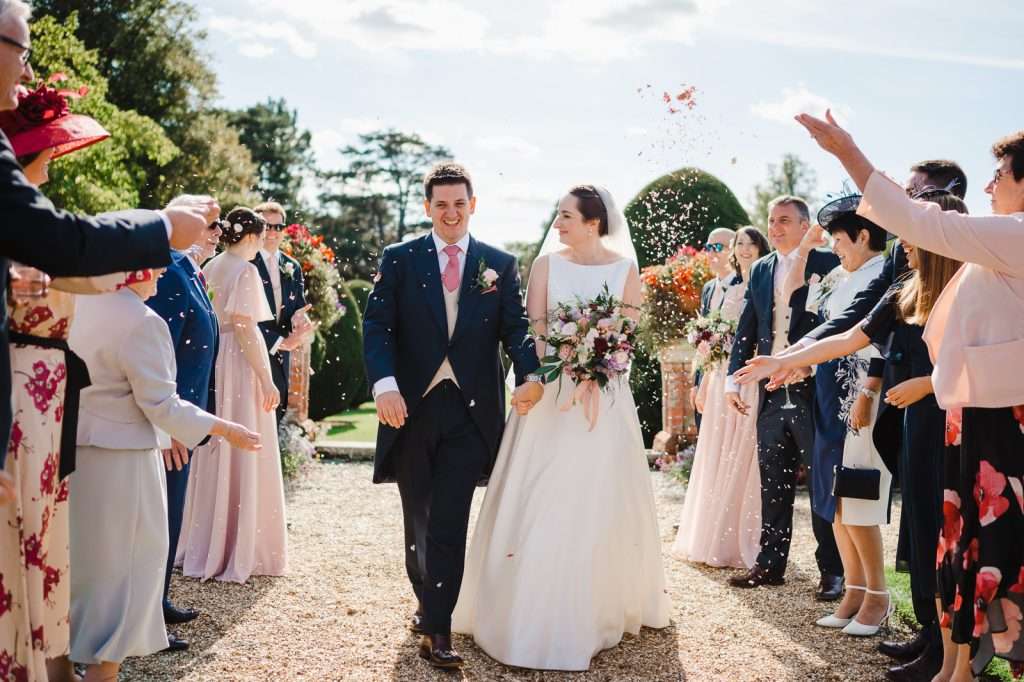 Happy Couple Walking down the confetti aisle Your Ultimate Guide To Craft Your Wedding Day Timeline