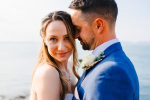 As the bride looks towards the camera it appears as though she looks through the lens with the beautiful sea in the background - Picking Perfect Wedding Menu UK
