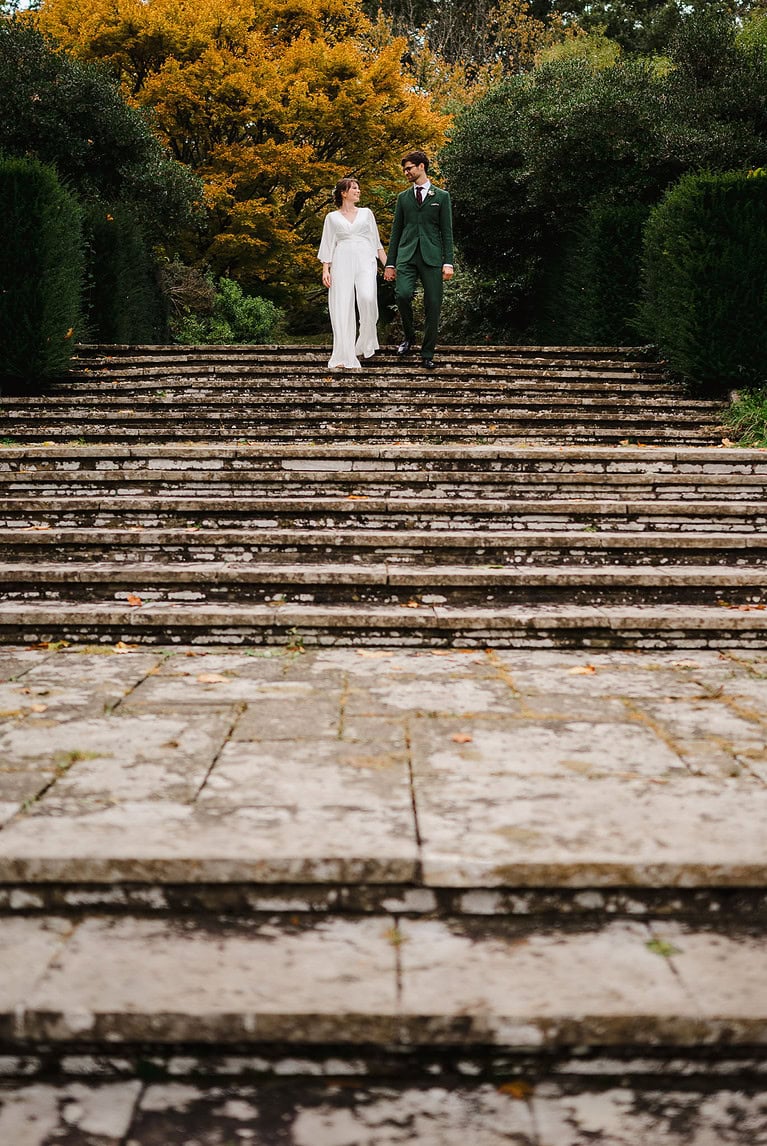 Just married and taking a walk down some stairs surrounded by autumnal trees - Picking The Perfect Wedding Menu