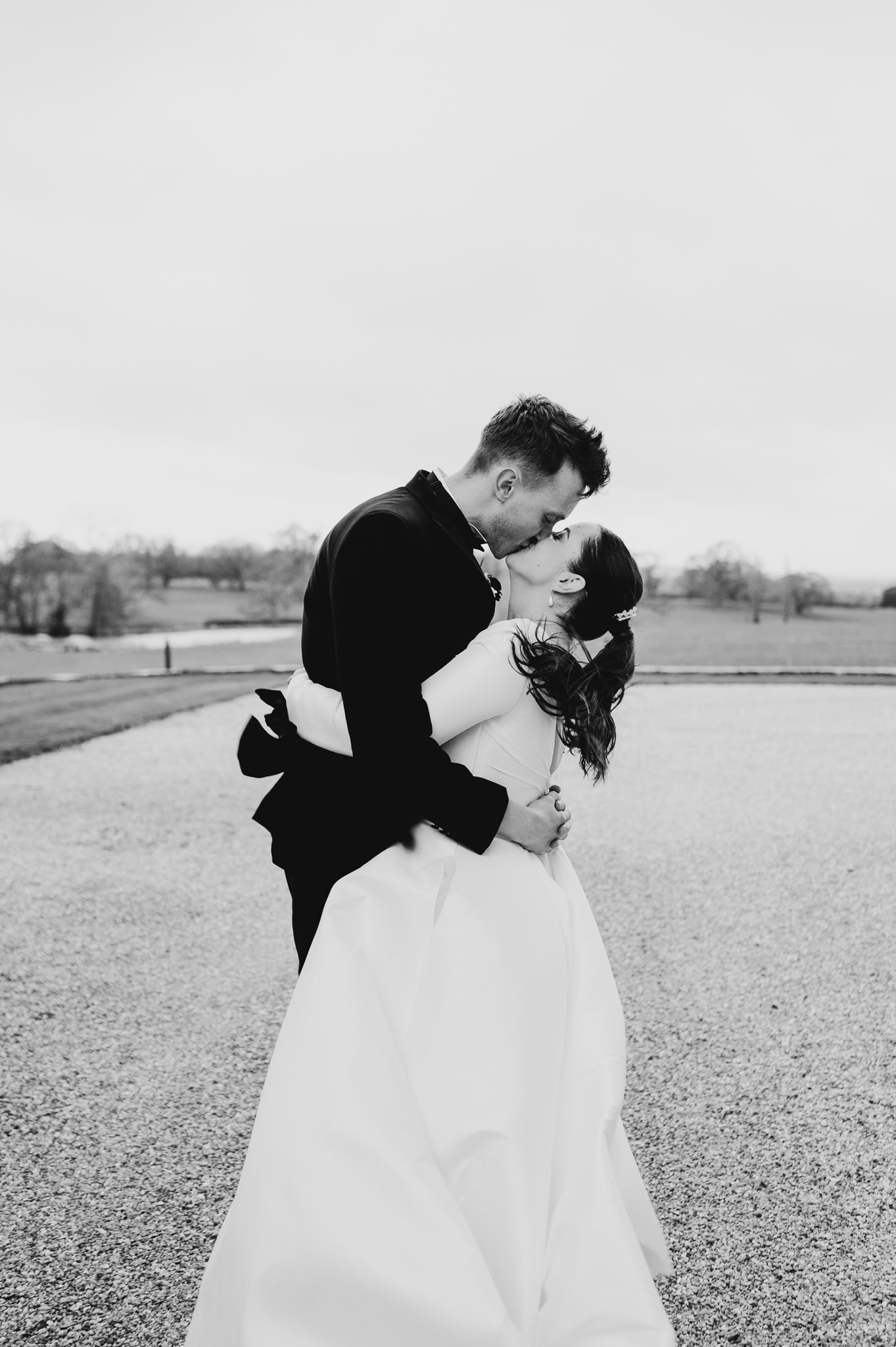 Happy couple sharing a kiss after getting married at Rockbeare Manor