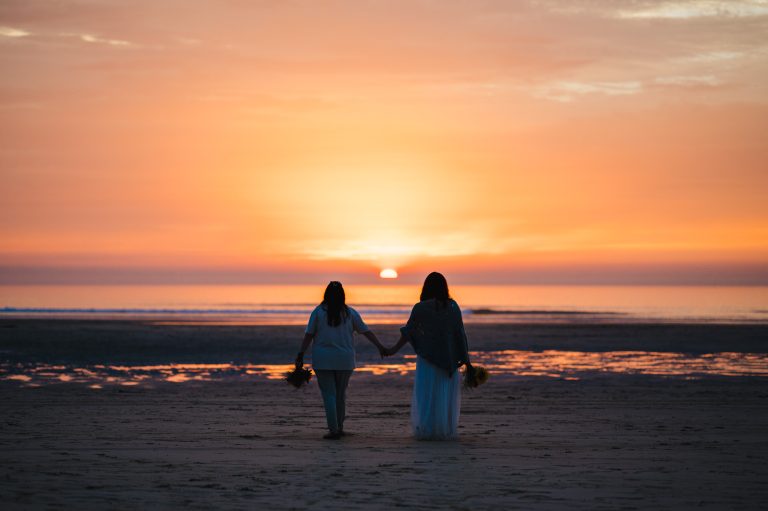 Couple who decided to elope to Cornwall finishing their final celebrations by watching the sunset at Gwithian - Is A Non-Traditional Wedding Right For You? - Cornwall Elopement