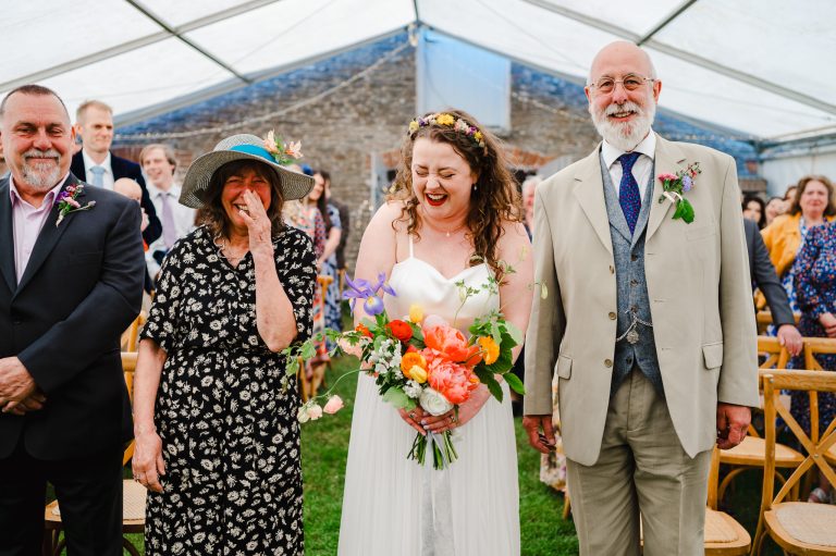 Bride Walking down the aisle with her parents enjoying the time before she says I do