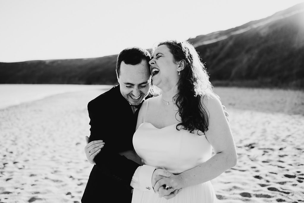 Black and white photo of wedding couple laughing