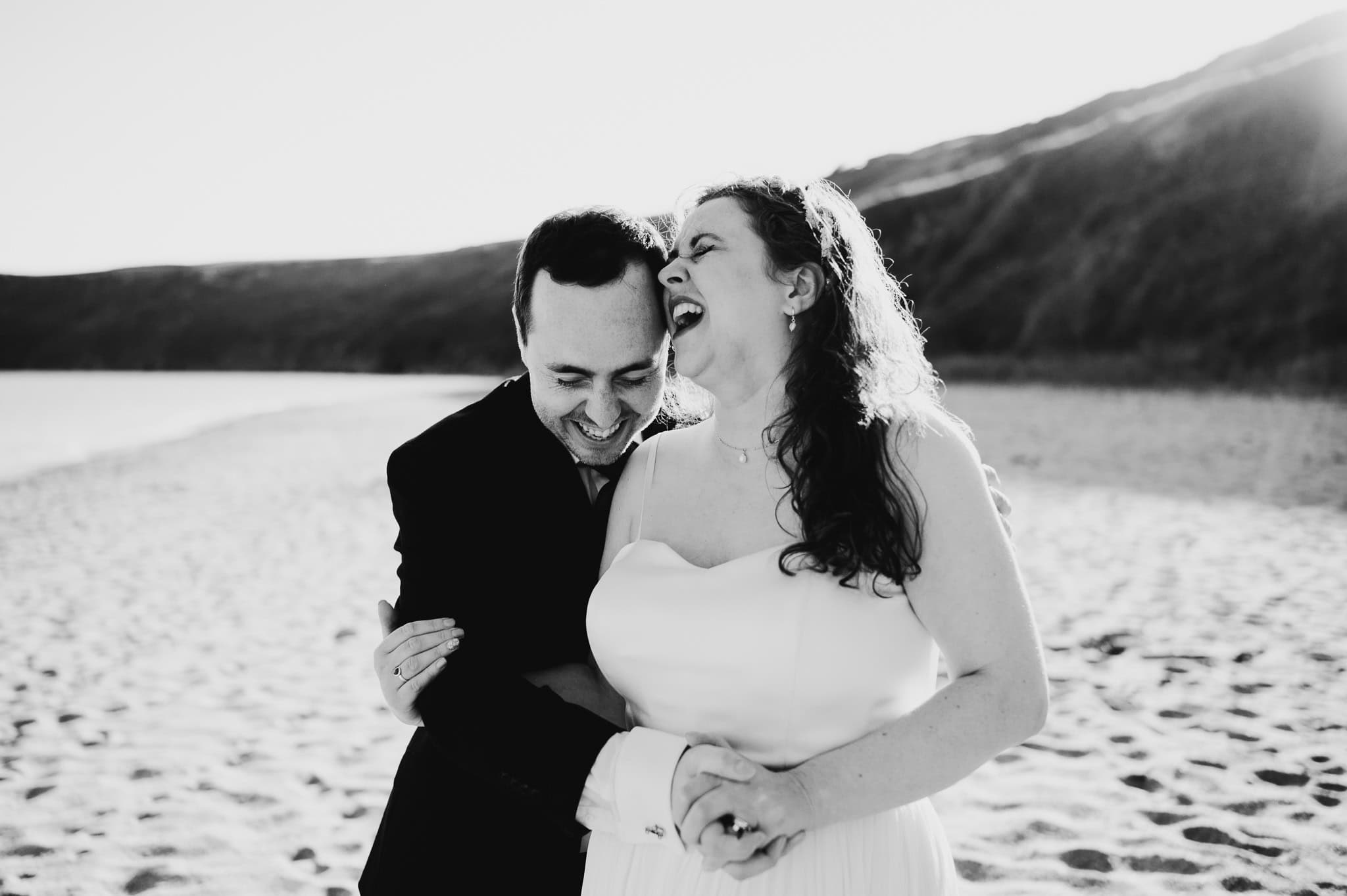 Black and white photo of wedding couple laughing