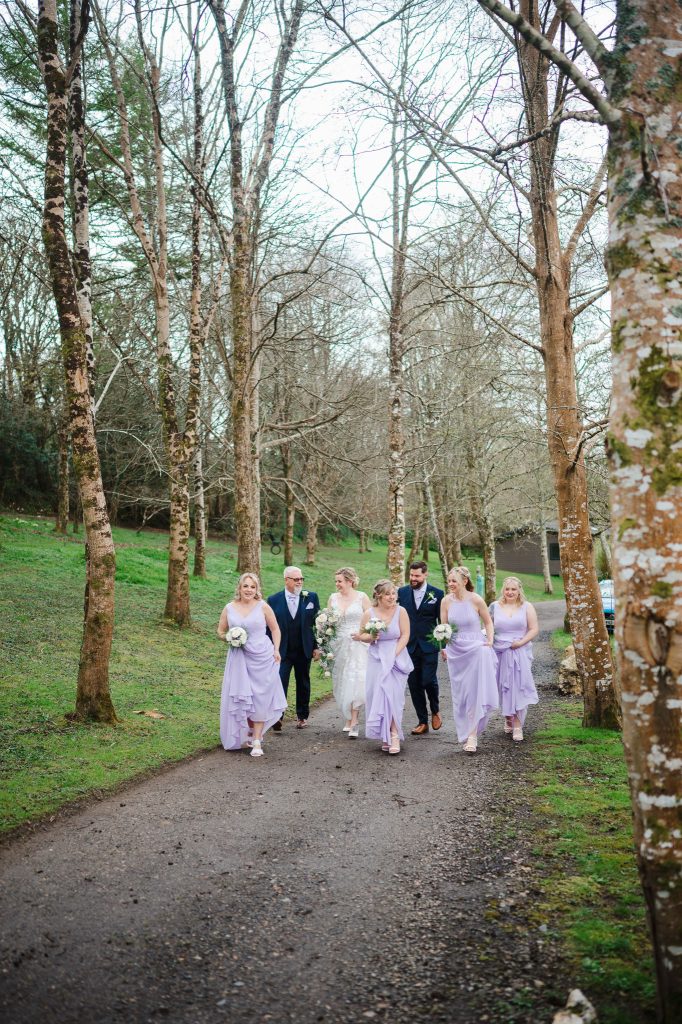 Bridal party walking through woodland at Chycara
