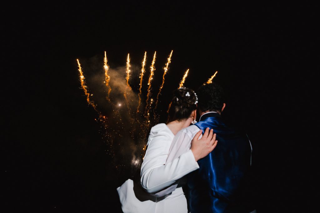 Wedding day fireworks display at Polurrian, Cornwall, with the happy couple in the foreground