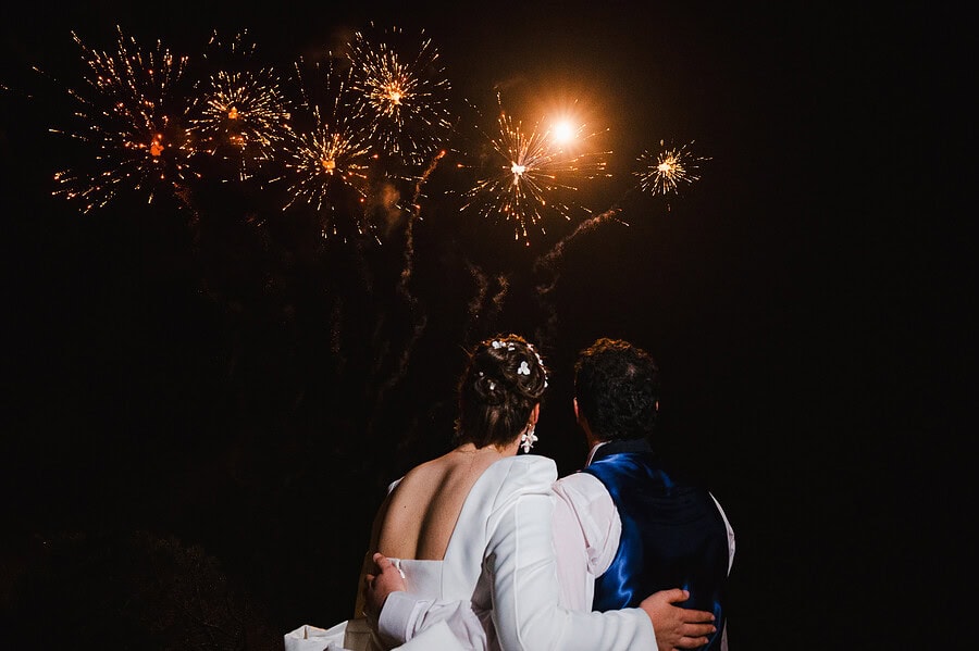 Wedding day fireworks exploding in the dark sky as the happy couple look out watching the firework display for a Polurrian Hotel Wedding