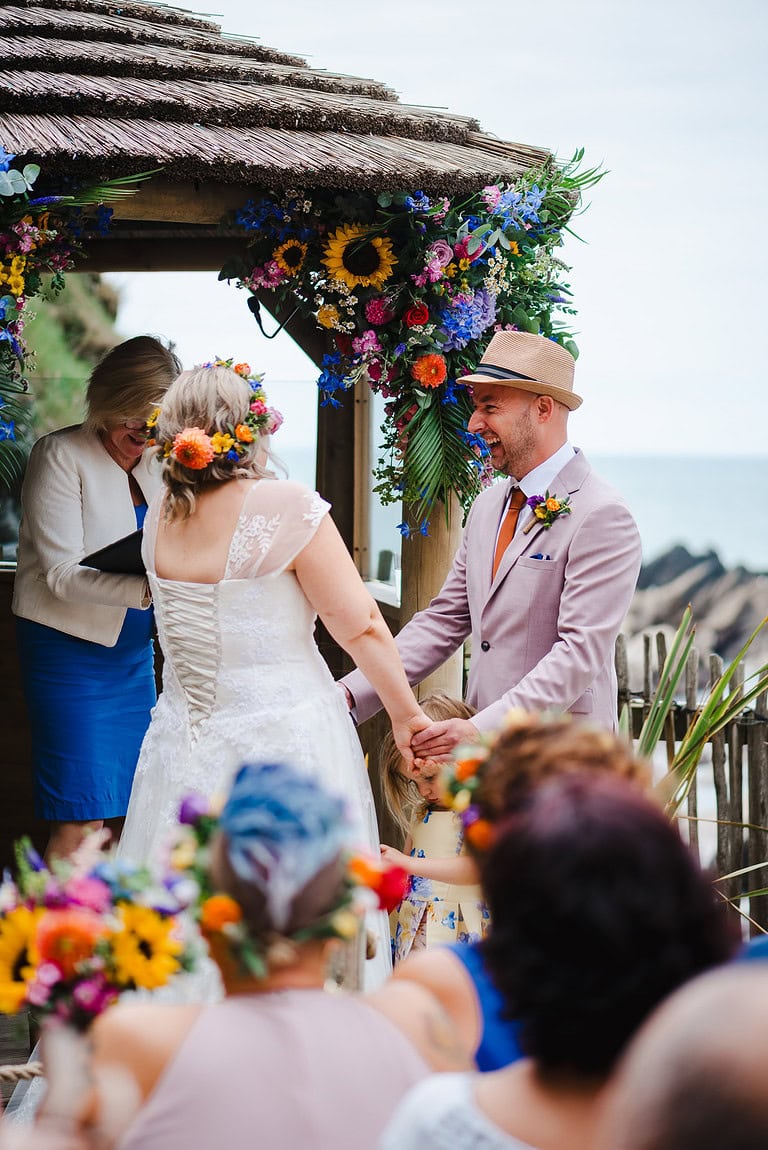Bride and Groom laughing during their wedding ceremony at Tunnels Beaches Wedding