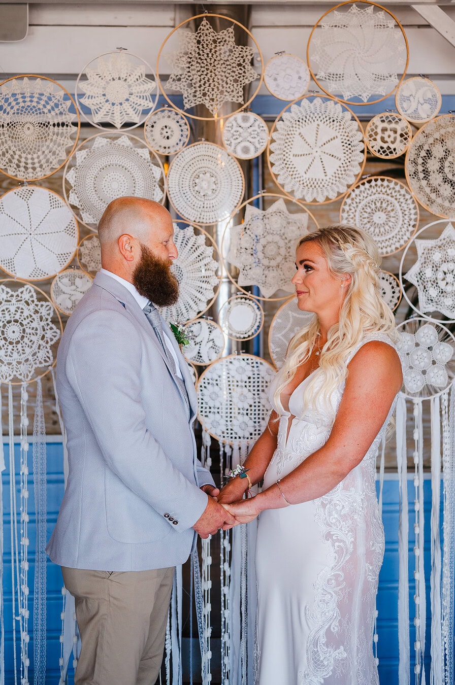 Bride and groom holding hands looking into each others eyes
