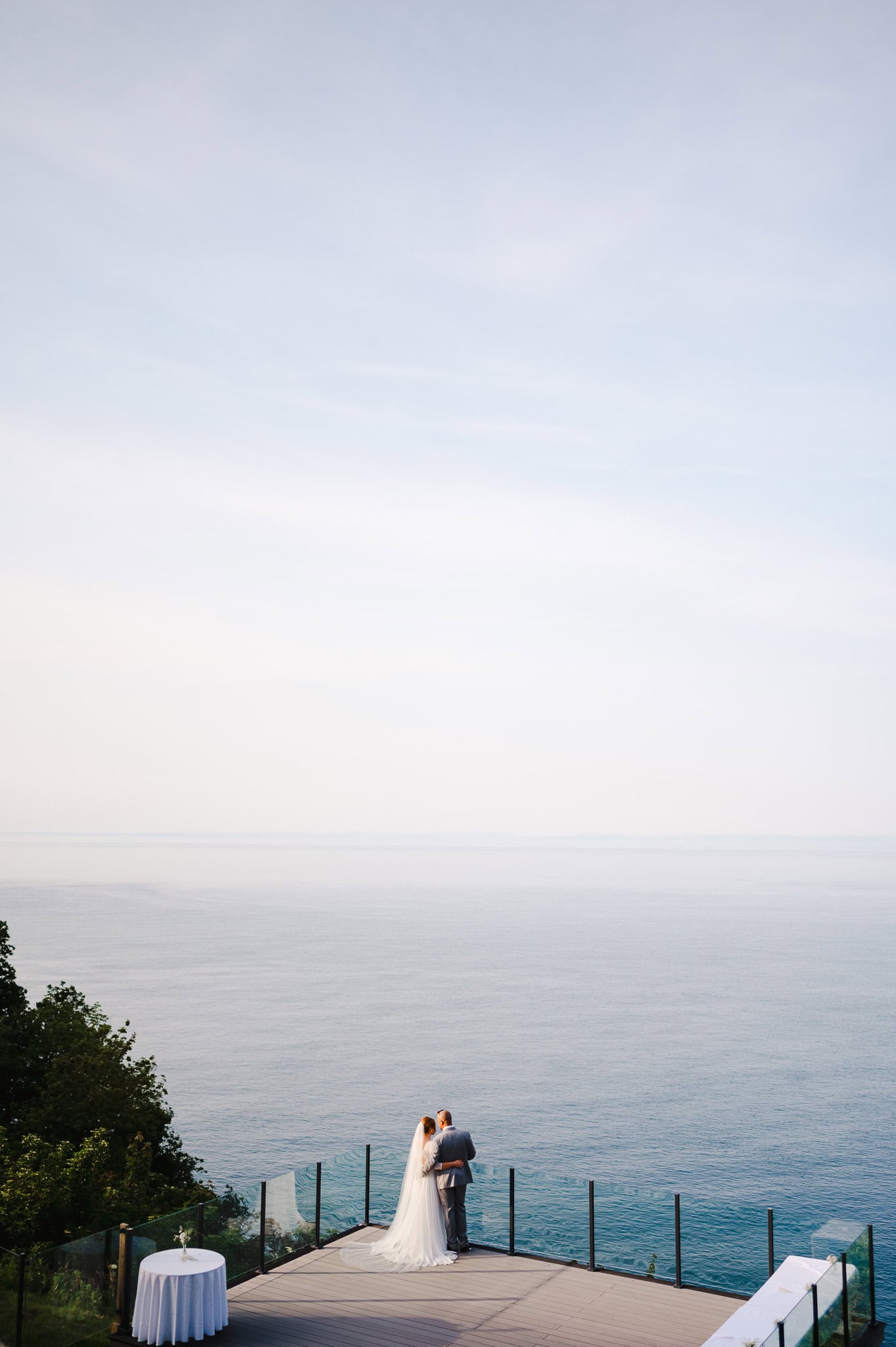 Bride and groom watch the sunset over the sea at Sandy Cove hotel