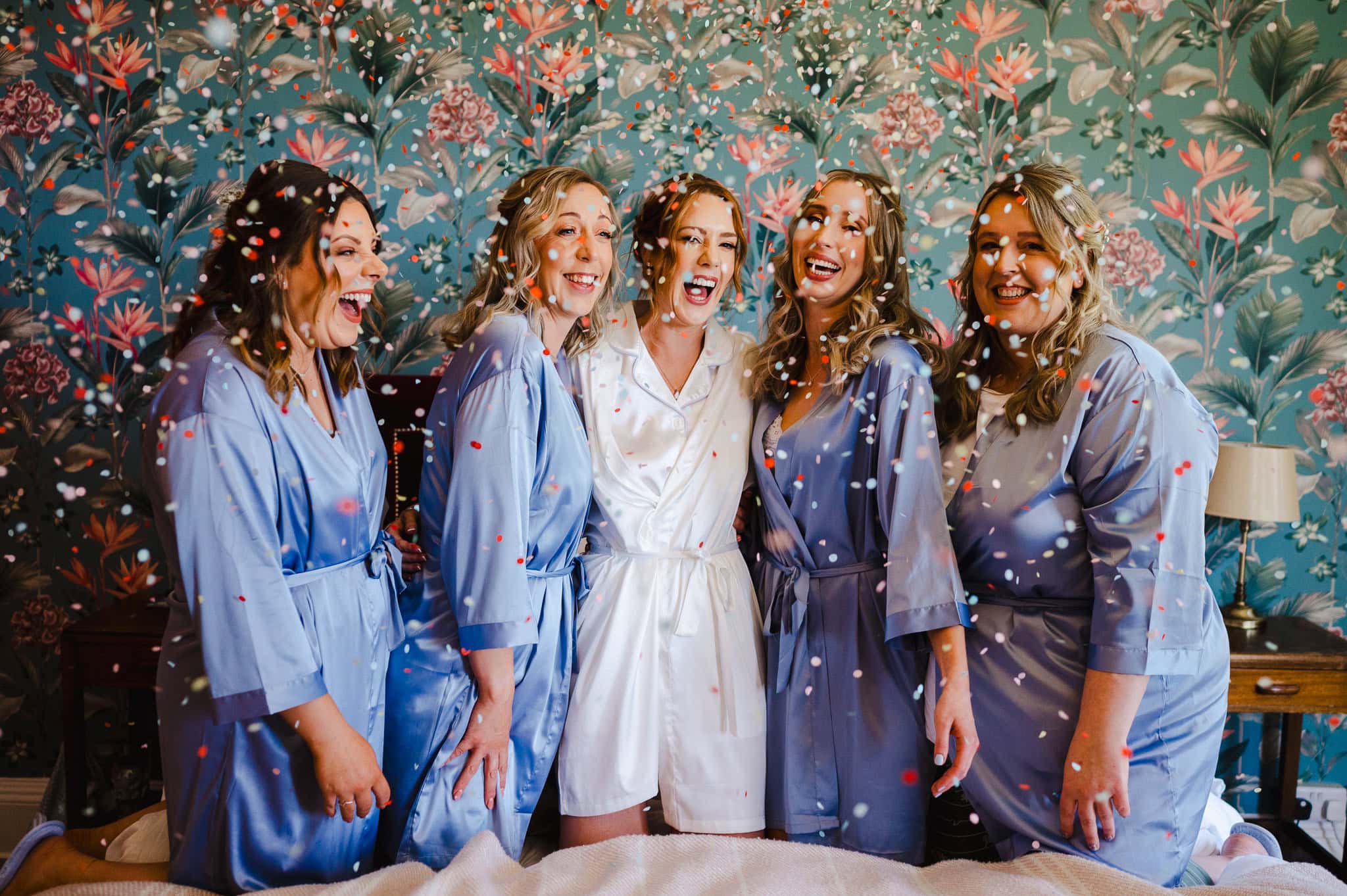 Bridal party laughing as confetti is thrown in the air during bridal prep