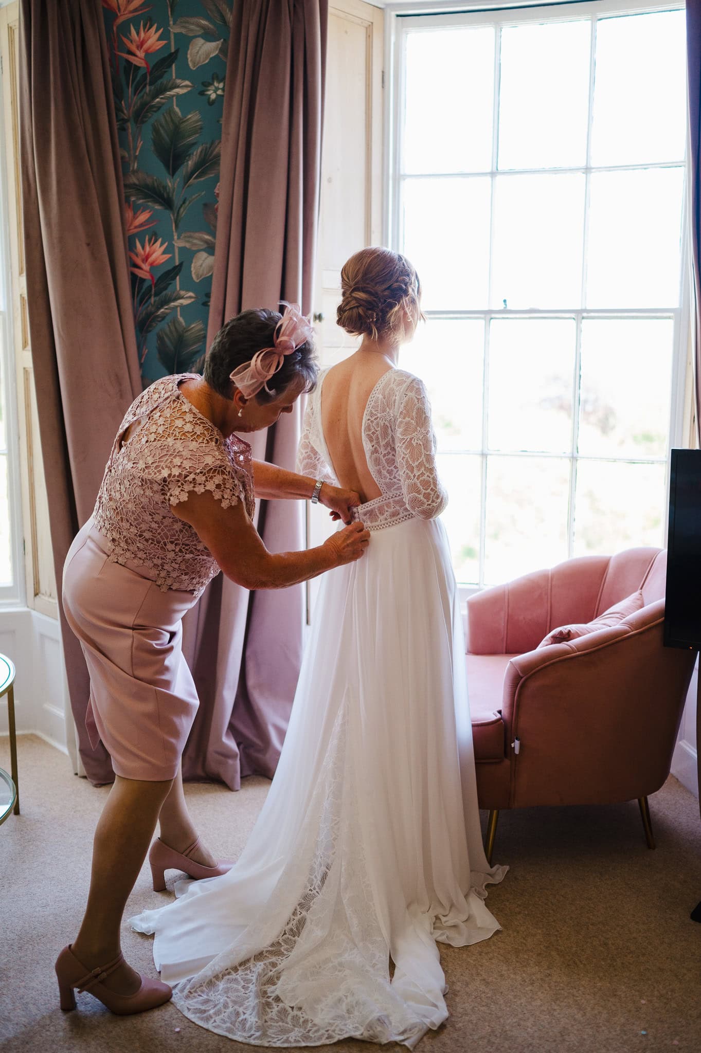 Brides mum tying up the brides wedding dress