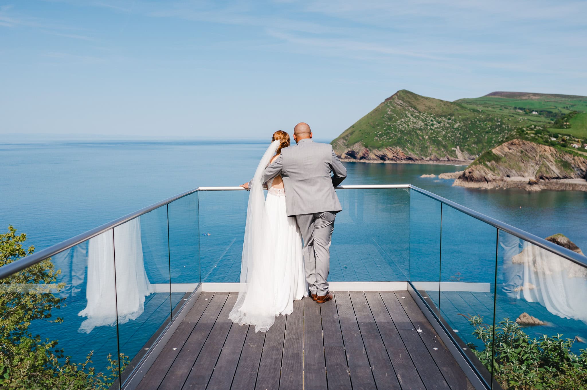 The Happy couple arm in arm as they look at the ocean view of Sandy Cove Hotel