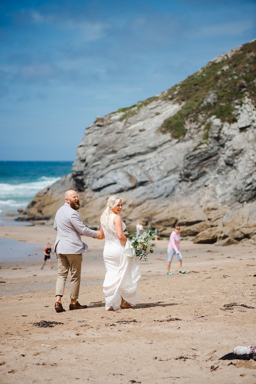 Wedding couple walking along the Lusty Glaze Beach