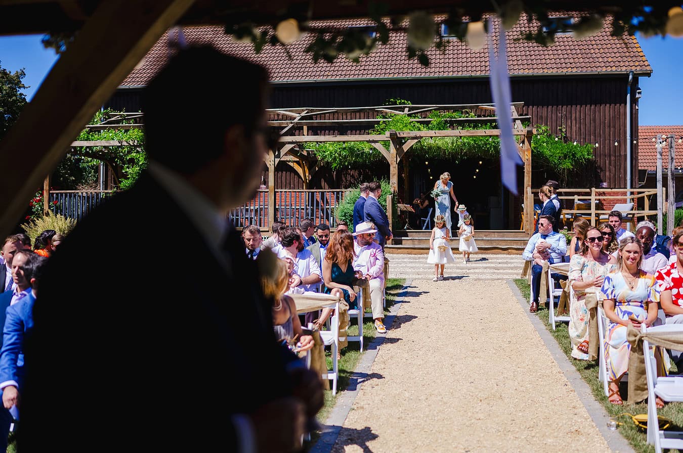 Bridesmaids start to walk down the aisle at Frgoinwell Vineyard