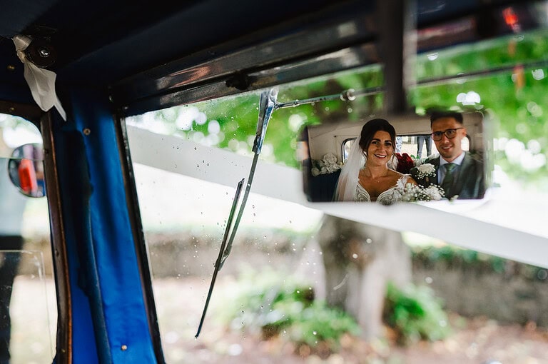 Couple In vintage car on their way to Tawstock Court - Wedding photographer cost