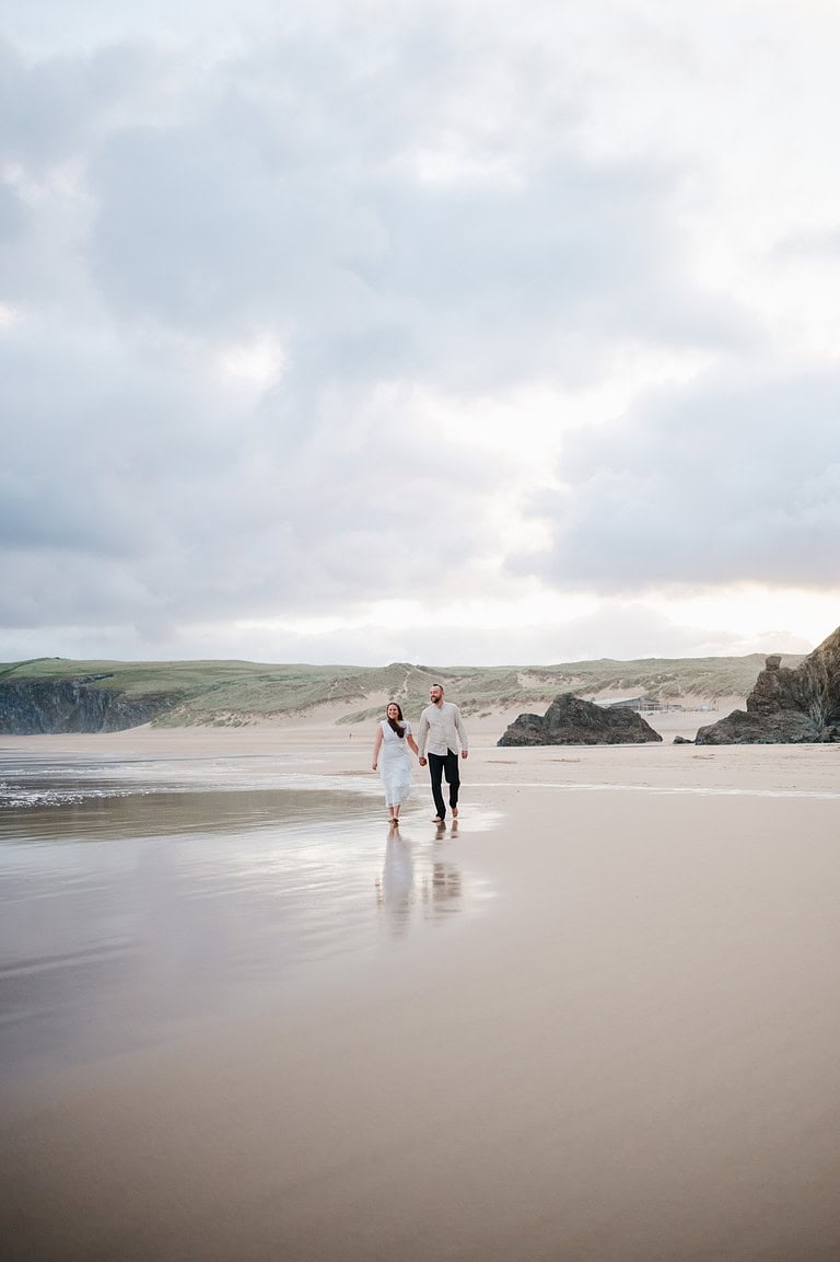 Reflections in the golden sand as the sun rises behind the happy couple
