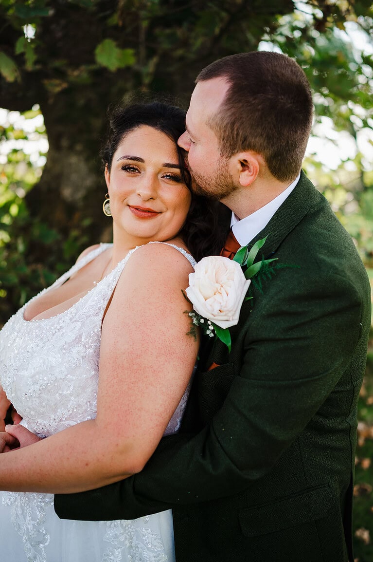 Groom gives the bride a kiss on the forehead
