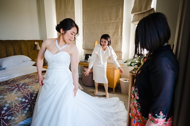 Bridesmaid pulling out the brides wedding dress