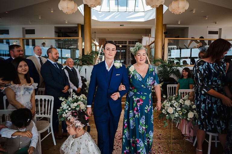 Bride walking down the wedding aisle with her mum