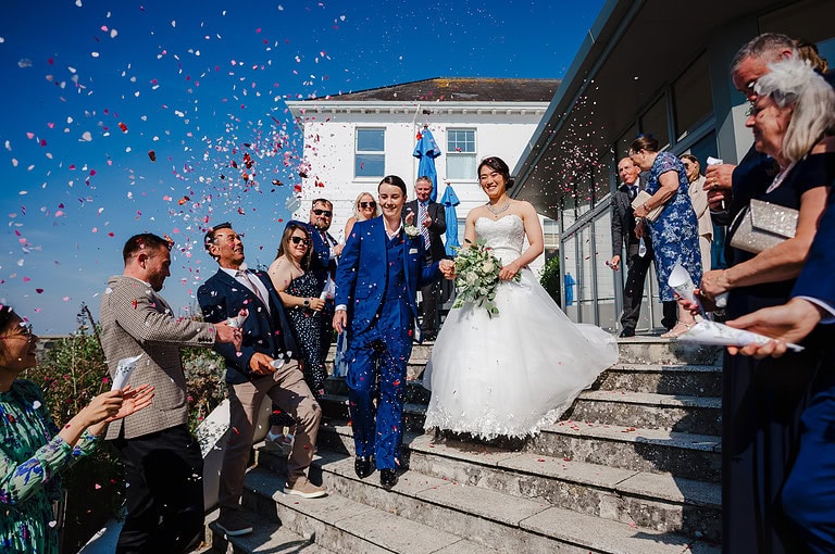 Wedding confetti at Polurrian on the lizard surrounded by a bright blue sky