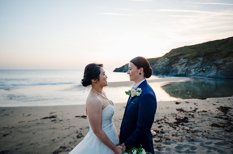 Couple photos against the sea with the sunset in the background at Polurrian