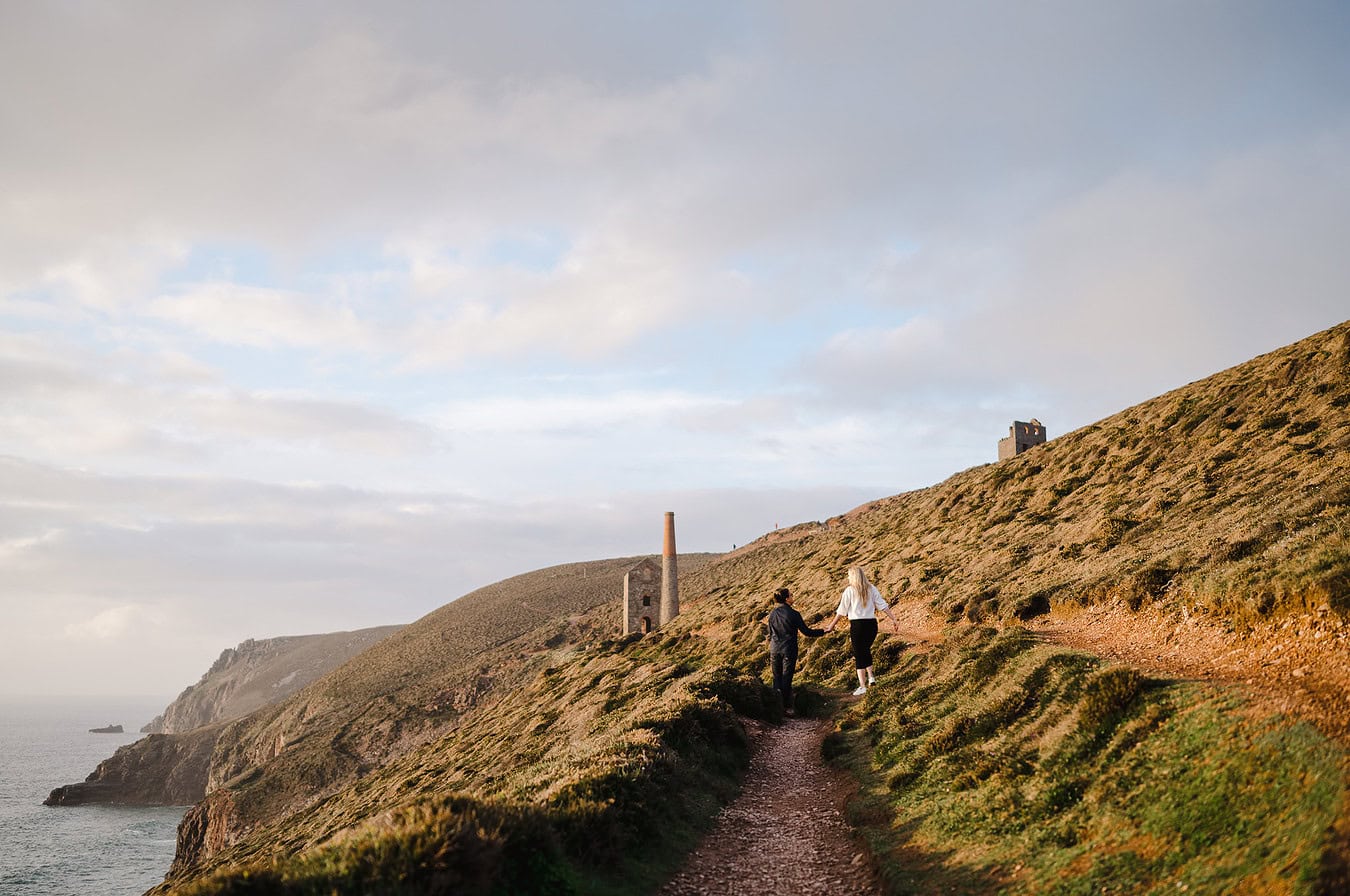 Walking off into the sunset along the St Agnes coast path by Cornwall Engagement Photographer, Jake Timms Photography