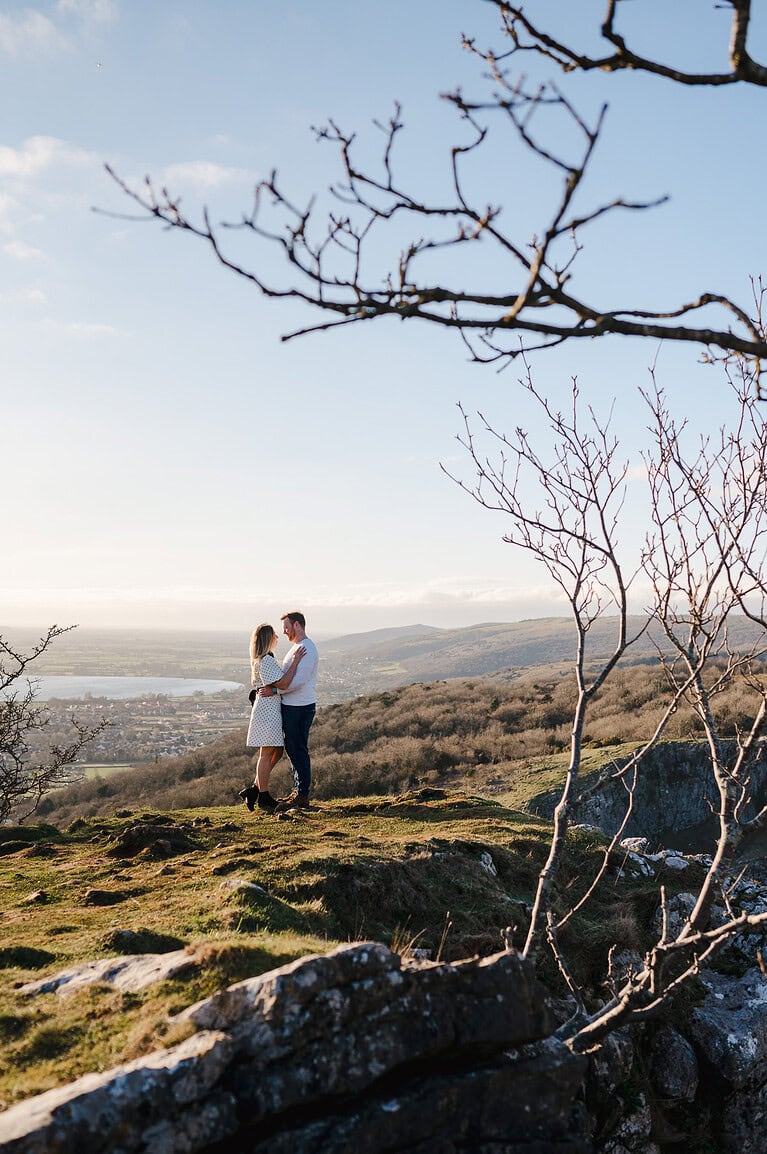 Standing on the top of the Cheddar Gorge valley overlooking the peacful town below at sunset by Somerset engagement photographer, Jake Timms Photography