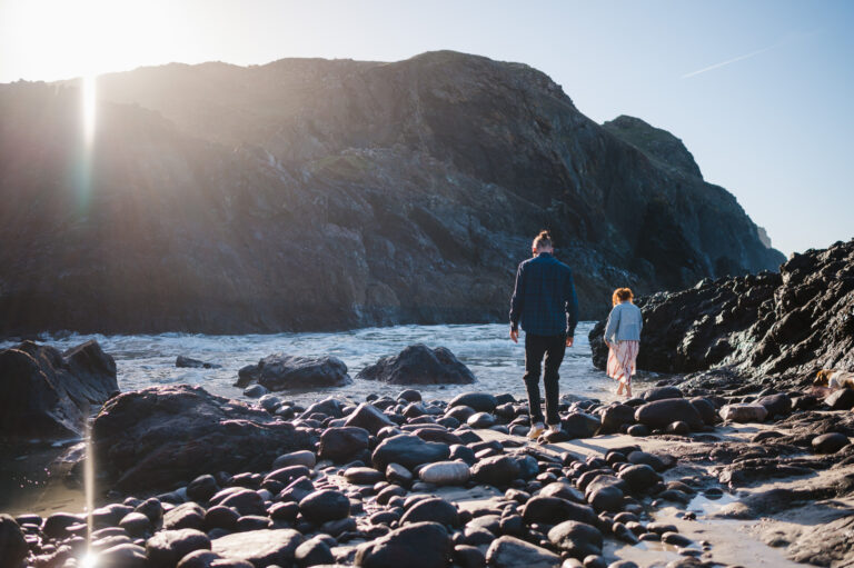 Walking along the beach towards the sea at Kynance Cove, Cornwall