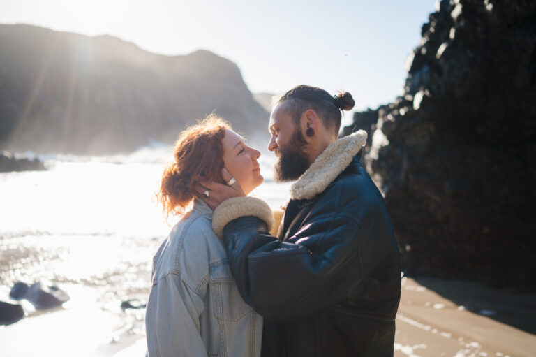 The moment before a kiss as the happy engaged couple bring each other in during their Kynance Cove engagement photo shoot
