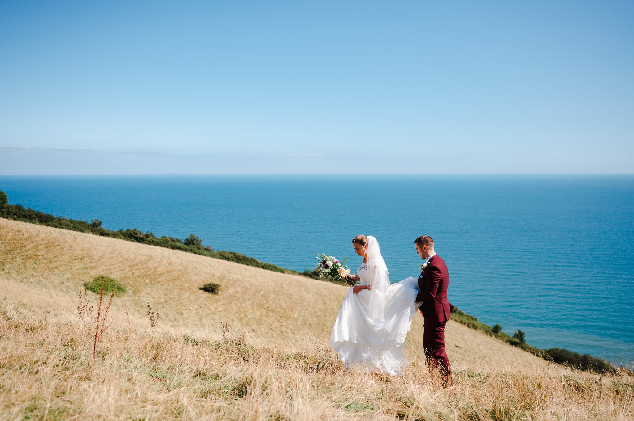 Couple walk along the beautiful coast close to Exeter by Exeter Wedding Photographer Jake Timms Photography