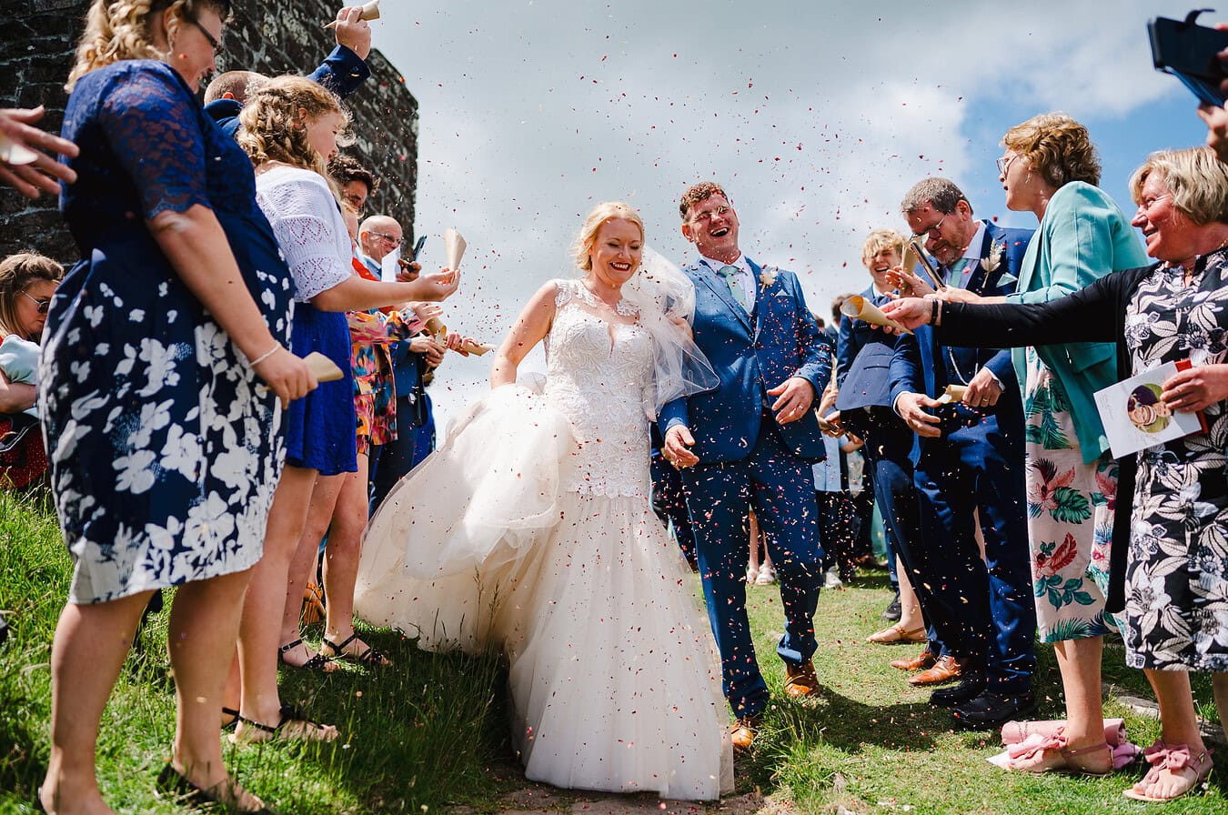 Wedding confetti falls in abundance over the happy newly married couple by Exeter Wedding Photographer Jake Timms Photography