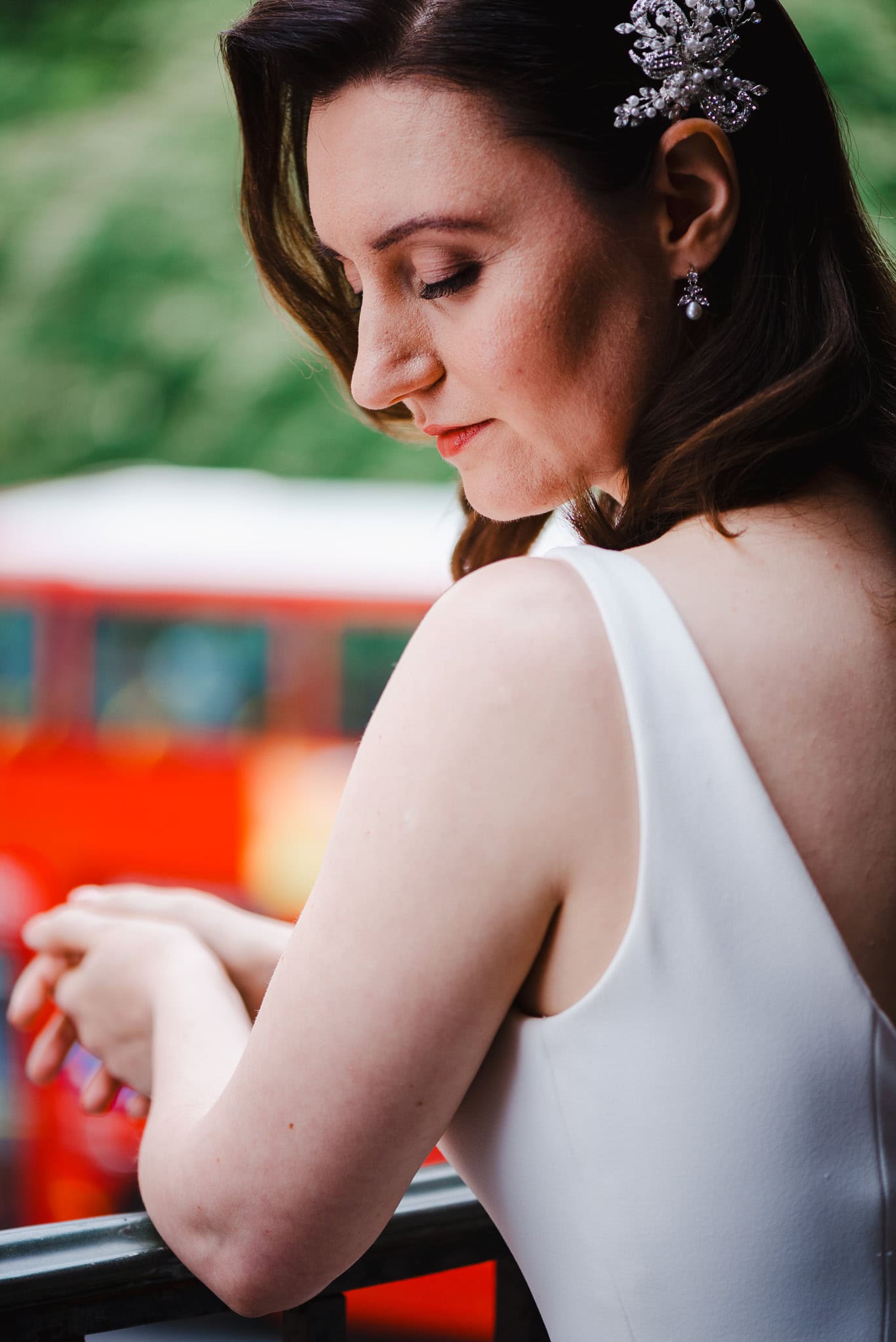 Bride looking down as the famous London red bus passes