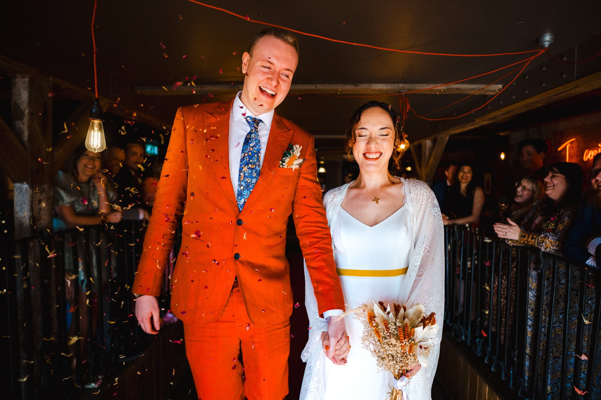 Bride and groom walk the plank as confetti is thrown over them by Bristol wedding photographer, Jake Timms Photography